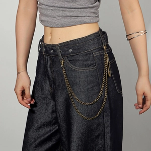 Detail of vintage punk pants chain with safety pin and gold metal double layers