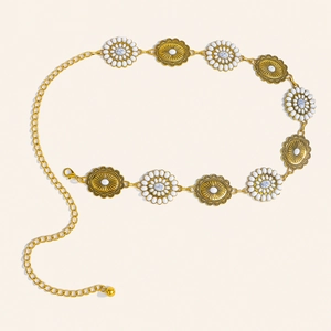 Detail of bohemian gold chain belt featuring floral metal plates and white faux stone