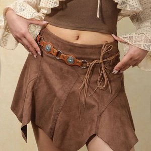 Detail of vintage punk belt with turquoise inlay on brown suede skirt with asymmetric hem