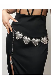 Close-up of silver metal heart chain belt with hammered texture on a black dress