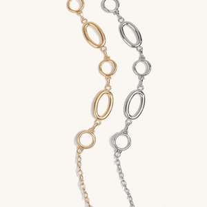 Close-up of minimalist gold and silver oval link body chains for dresses