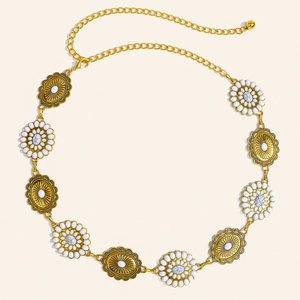 Detail of golden metal chain belt with daisy floral motifs and white gemstone elements