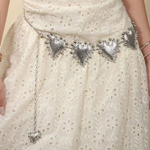 Minimalist silver heart metal waist chain with textured heart charms on white dress