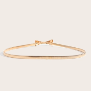 Vue détaillée de la ceinture élastique dorée avec une boucle en forme de nœud poli chic