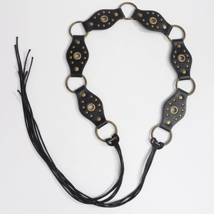 Detail view of black vintage leather belt with metal studs, rings and long fringe tassels