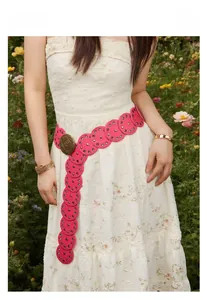 Detail eines rosa Boho-Ledergürtels mit Metallösen und Vintage-Schnalle am Model