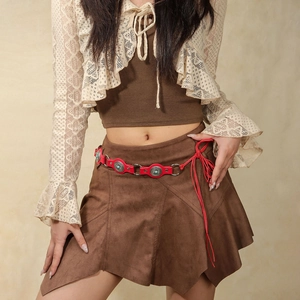Red bohemian leather belt with turquoise-style silver studs on a western-style skirt