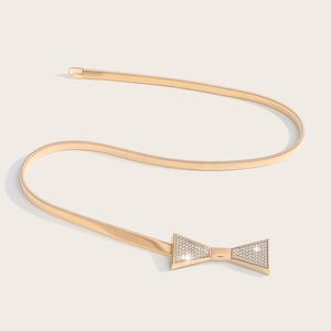 Gros plan sur la ceinture dorée élastique avec boucle en nœud sertie de strass