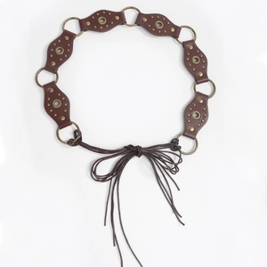Detail of bohemian braided waist chain featuring brown faux leather and brass rings