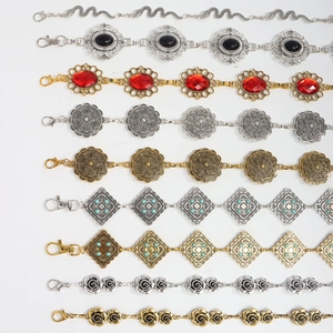 Dettaglio di nove catene in metallo vintage per la vita con intarsi di pietre preziose