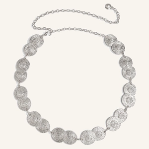 Detail of silver bohemian metal waist chain featuring textured spiral round discs
