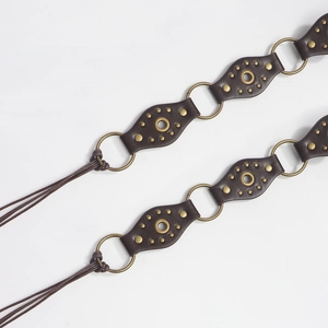 Macro detail of dark brown leather diamond pieces linked by antique bronze metal rings