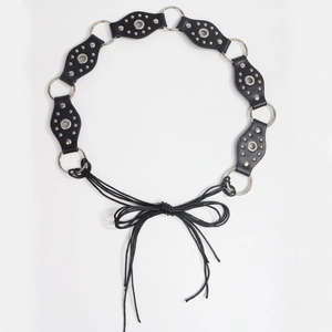 Detail of a vintage-style black leather belt featuring silver studs and metal ring links