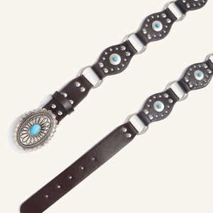 Close-up of Western style leather belt with turquoise studs and vintage floral buckle