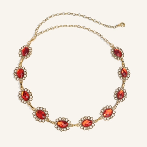 Dettaglio catena vintage in oro con gemme rosse ovali e decorazioni in filigrana fine