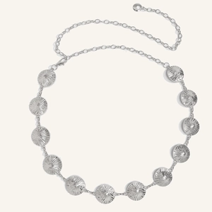 Detail shot of bohemian silver metal waist chain with textured circular pattern plates