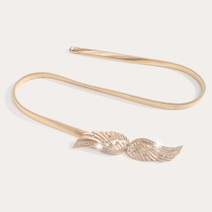 Détail de la boucle ailes dorées avec strass sur la fine ceinture chaîne à ressort