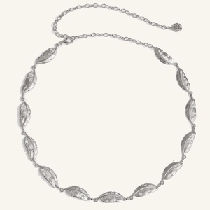 Detail of vintage silver feather metal waist chain with delicate texture and flower pendant