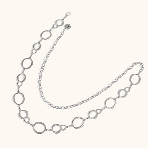Detail van de zilveren gelaagde lichaamsketting met vintage getextureerde metalen ringen