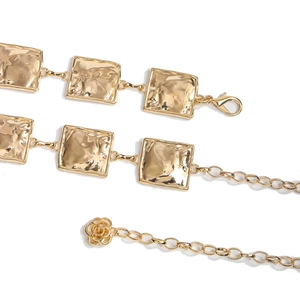 Detail view of square hammered texture gold metal waist chain with a rose pendant
