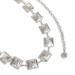 Detail of silver metal waist chain with hammered square links and delicate rose pendant