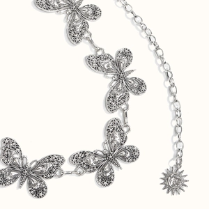 Makrodetail der silbernen Schmetterlings-Taillenkette mit Vintage Sonne und Mond Anhänger