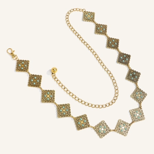 Dettaglio catena in oro stile boho con motivi quadrati e perline color turchese