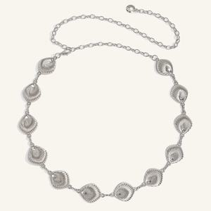 Detail of silver shell-shaped metal belt with adjustable chain and starfish charm for women