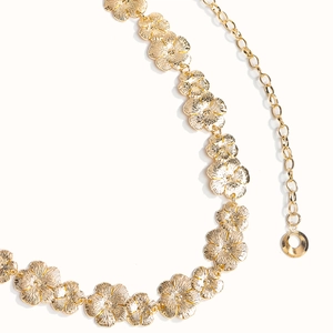 Detail einer Vintage-Goldblumen-Kette mit aufwendig geprägten floralen Metallgliedern