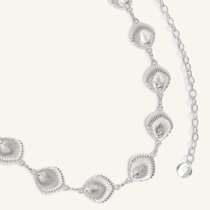 Detailed close-up of a silver starfish and seashell metal waist chain for beach dresses