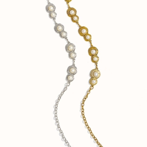 Detail of vintage gold and silver metal waist chains with embedded pearls and engravings