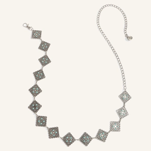 Dettaglio catena in argento stile boho con motivi floreali e perline turchesi