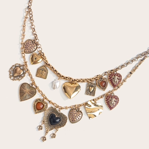 Detailed macro view of vintage gold multi-layered heart charms and metallic chain textures