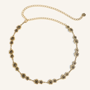 Dettaglio della cintura a catena dorata con rose decorative e chiusura regolabile