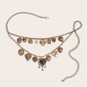 Detail of vintage gold layered waist chain with heart pendants and textured charms