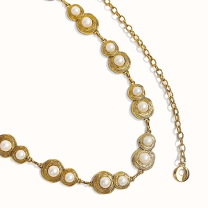 Detail of vintage gold metal waist chain with white pearls and spiral texture edges