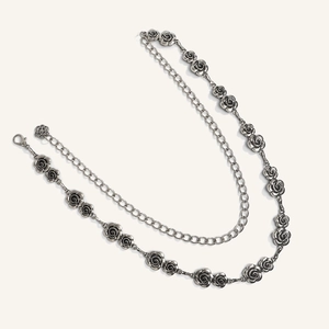 Dettaglio cintura a catena vintage in argento con rose e chiusura a moschettone