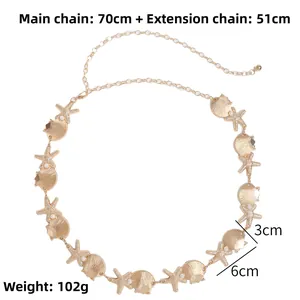 Detail of gold starfish and shell waist chain with pearls on a white background