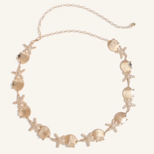 Close-up of golden starfish and seashell waist chain with faux pearls for beach dresses