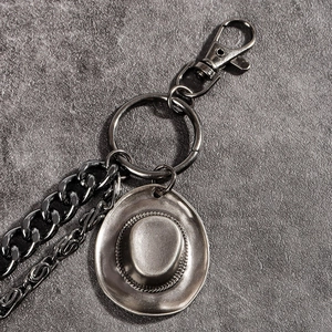 Detail of punk style double-layered metal trouser chain with cowboy hat pendant