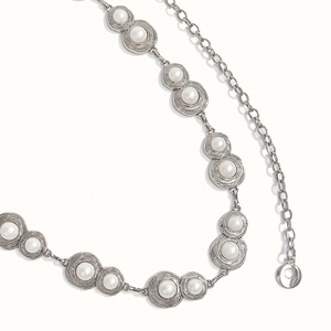 Detailed macro view of silver alloy waist chain featuring white pearl and double ring link
