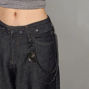 Vintage bronze punk waist chain with a cowboy hat pendant on dark denim jeans