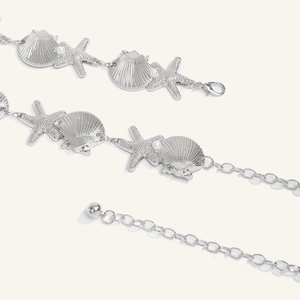 Detail of silver starfish and seashell body chain with delicate pearls and lobster clasp