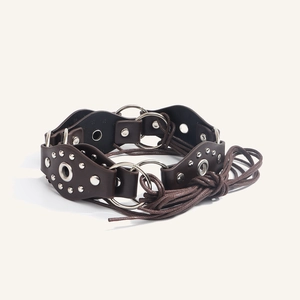 Detail view of American retro leather belt with metal rivets and decorative O-ring connector