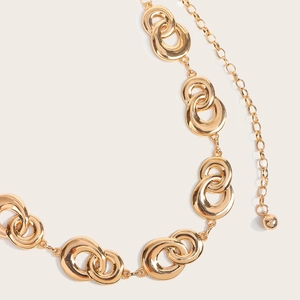 Detail of gold metal chain belt with interlocking double ring design and polished finish
