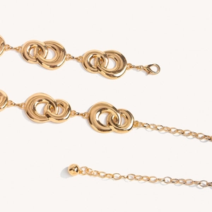 Close-up of golden metal waist chain featuring interlocking double loops and lobster clasp