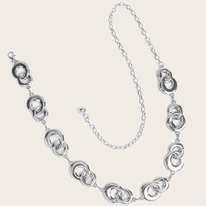 Detail of silver metal body chain featuring triple-interlocking rings and lobster clasp