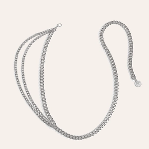 Detail einer silbernen mehrlagigen Metall-Taillenkette mit Karabiner und rundem Anhänger