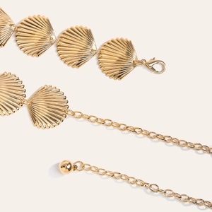 Vue macro détaillée de la chaîne de taille dorée avec des pendentifs en forme d'éventail