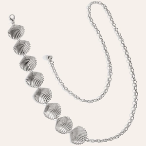 Détail de la chaîne de taille en métal argenté avec pendentifs coquillages et fermoir mousqueton